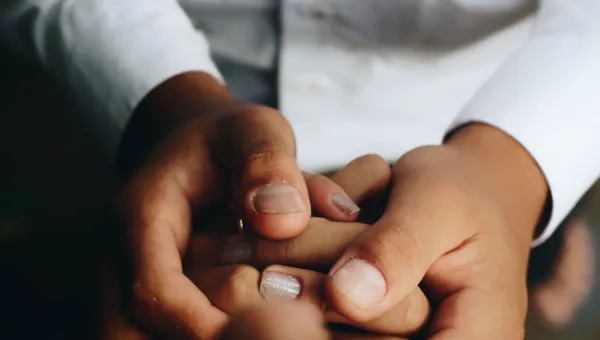 Photo of a set of hands holding another by Matheus Ferrero on Unsplash